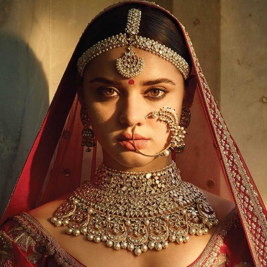 Indian bride in red and gold wearing traditional bridal jewellery